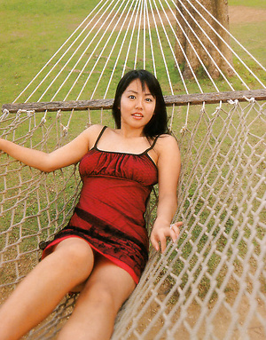 Sultry gravure idol tantilizes in her red bikini at the beach