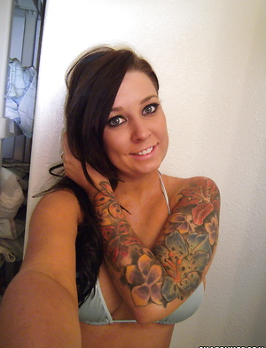 Busty girlfriend shows off her big fake tits as she strips out of her string bikini